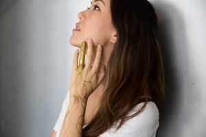 woman looking up with hand on face